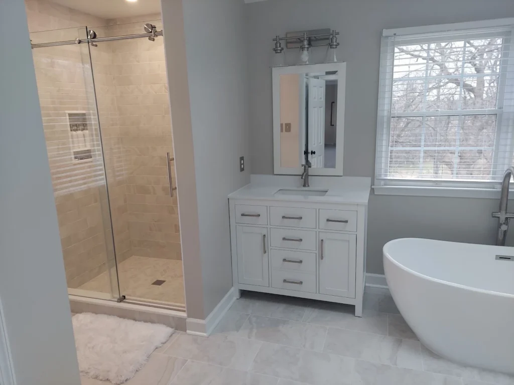 a modern bathroom remodel with stone accents and white furniture.